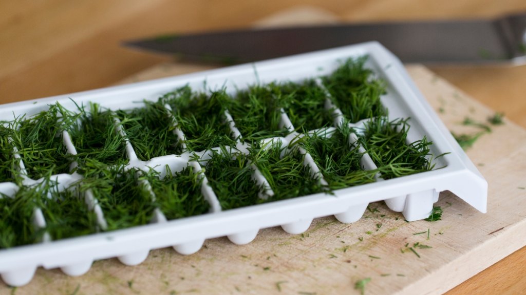 An ice cube tray being used to store herbs
