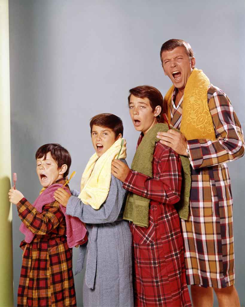 Mike Lookinland, US child actor, Christopher Knight, US child actor, Barry Williams, US child actor, and Robert Reed (1932-1992), pose wearing bathrobes and holding toothbrushes, yawning in a group studio portrait issued as publicity for the US television series, 'The Brady Bunch', USA, circa 1972. 