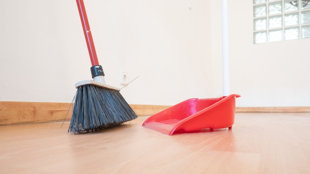 A broom sweeping a wood floor