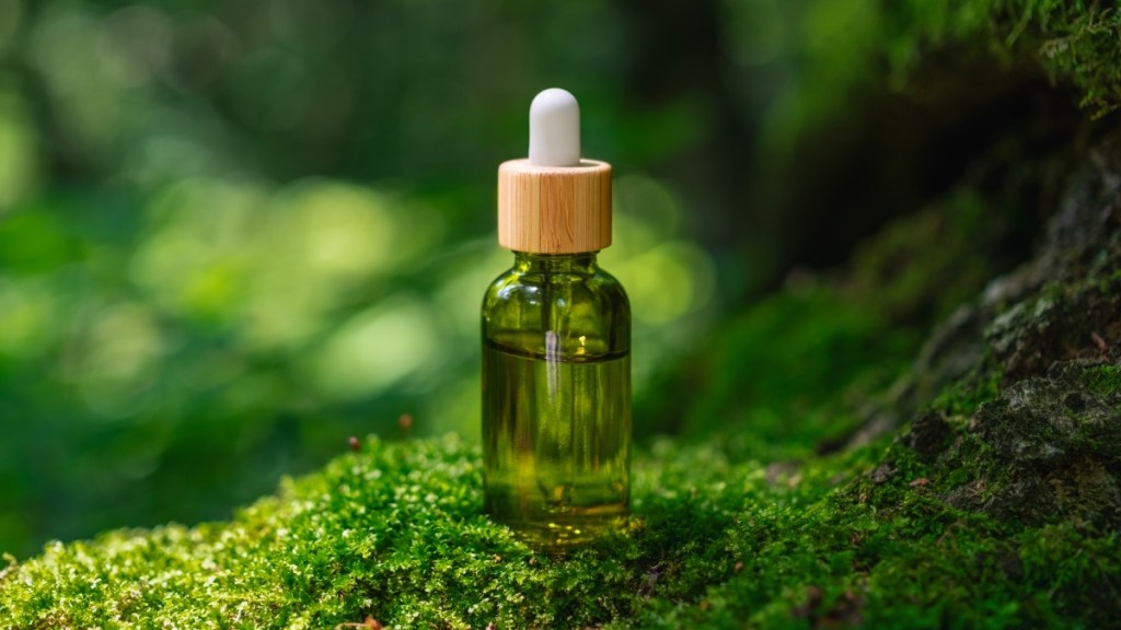 A vial of tea tree oil on green moss, which can be used to treat a skin ulcer