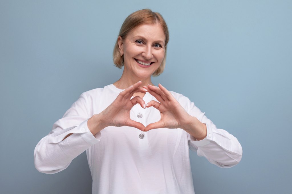 Smiling woman making a heart shape with her hands