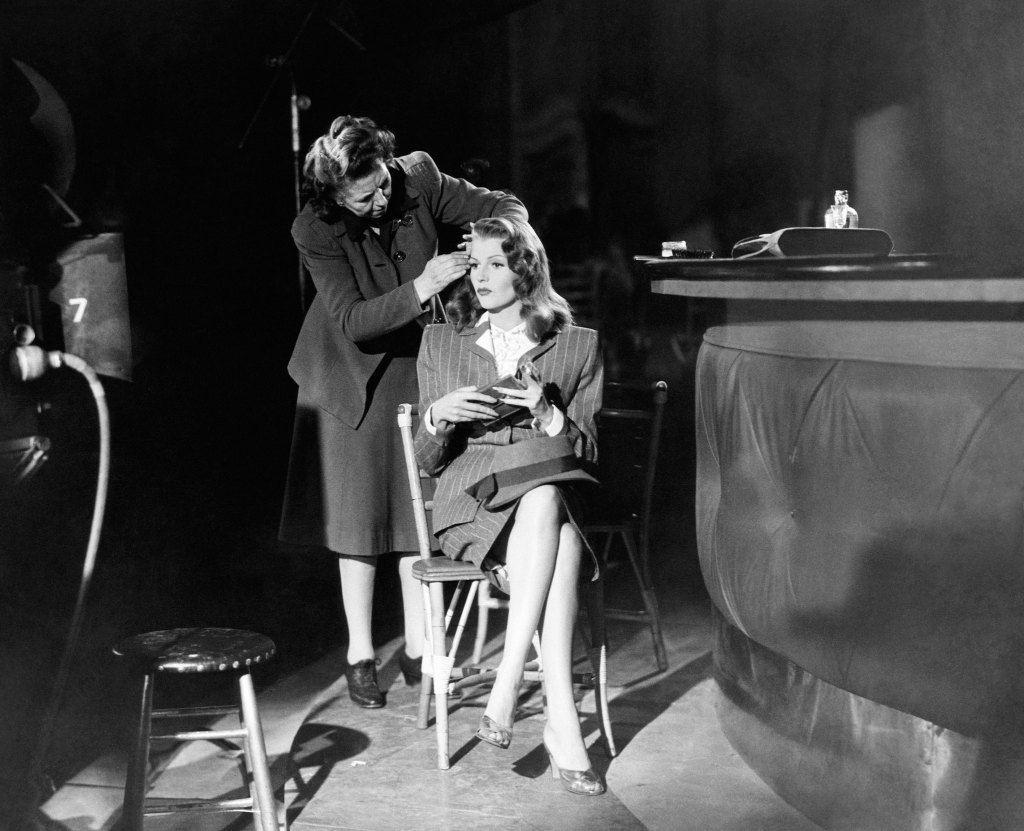 GILDA, Rita Hayworth, getting a touch-up on-set, 1946