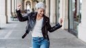 Happy woman walking down the street and doing a little dance