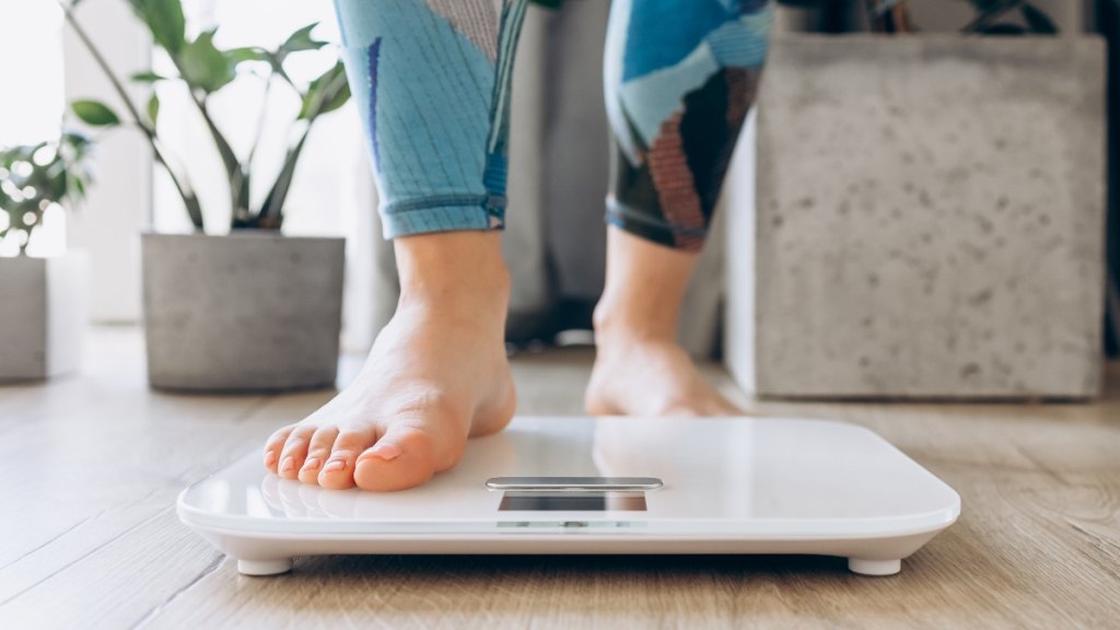 A woman stepping on a scale