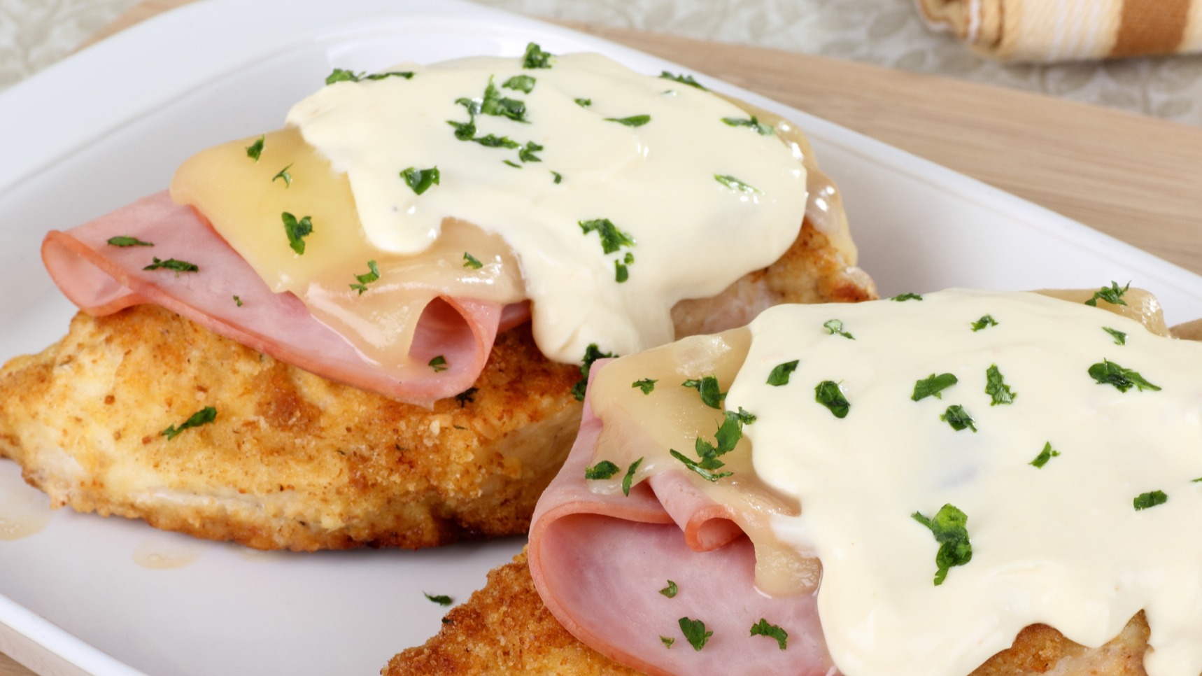 Stacked chicken cordon bleu with ham, cheese and Dijon sauce on serving platter