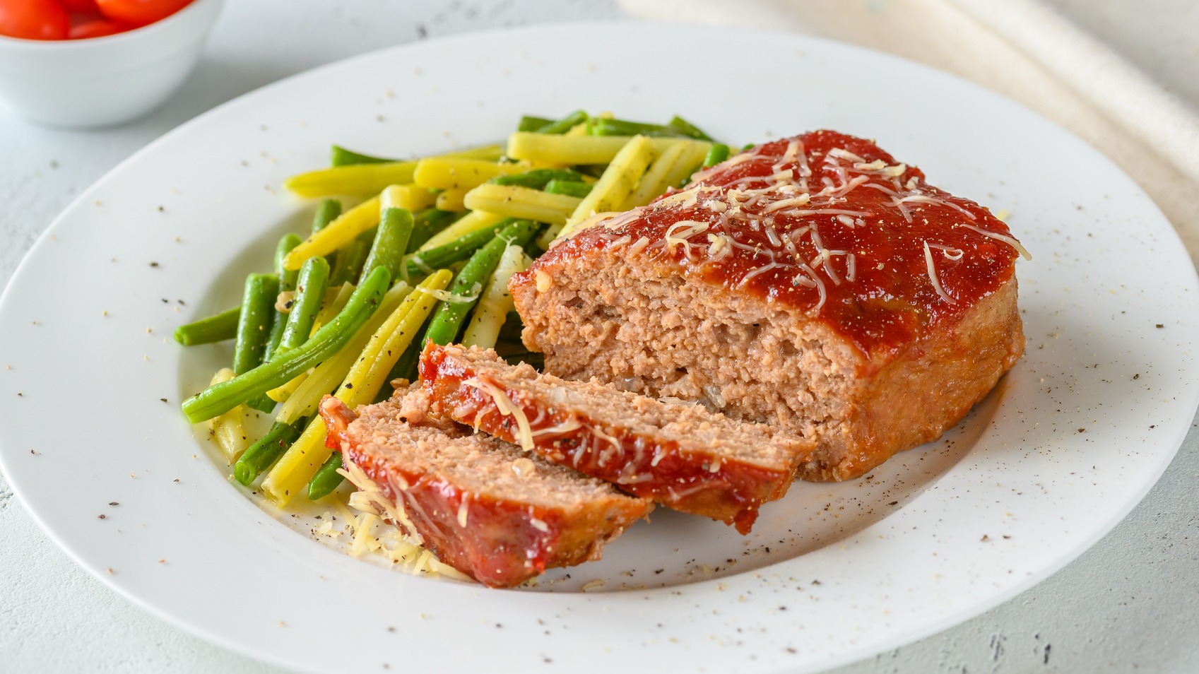 Ree Drummond's cheeseburger meatloaf sliced on plate with green beans