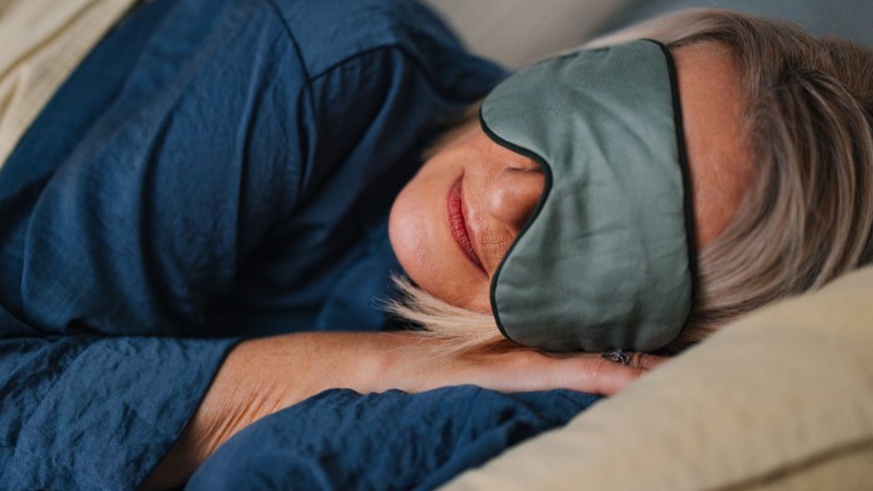 woman sleeping in bed wearing eye mask
