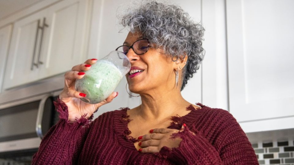 woman drinking green juice to lose weight with hypothyroid disease