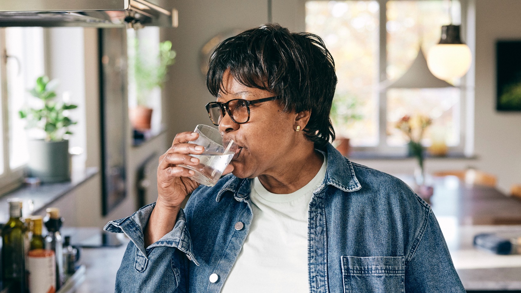 mature woman hydrating with glass of water to help lower a1c