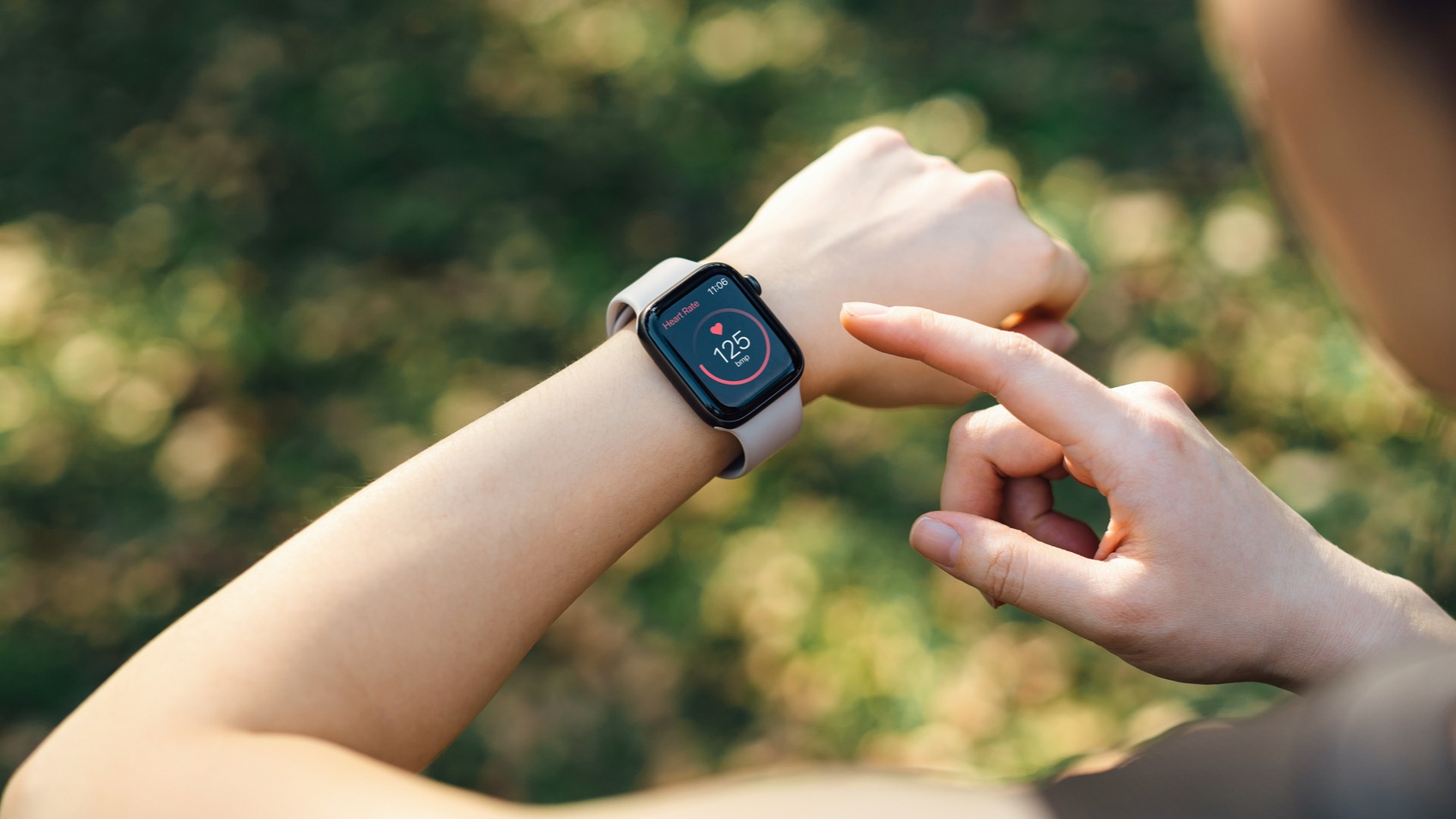 mature woman checking her hrv by age on her smartwatch while exercising