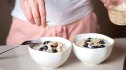 Mature diabetic woman making oatmeal bowls for breakfast in kitchen