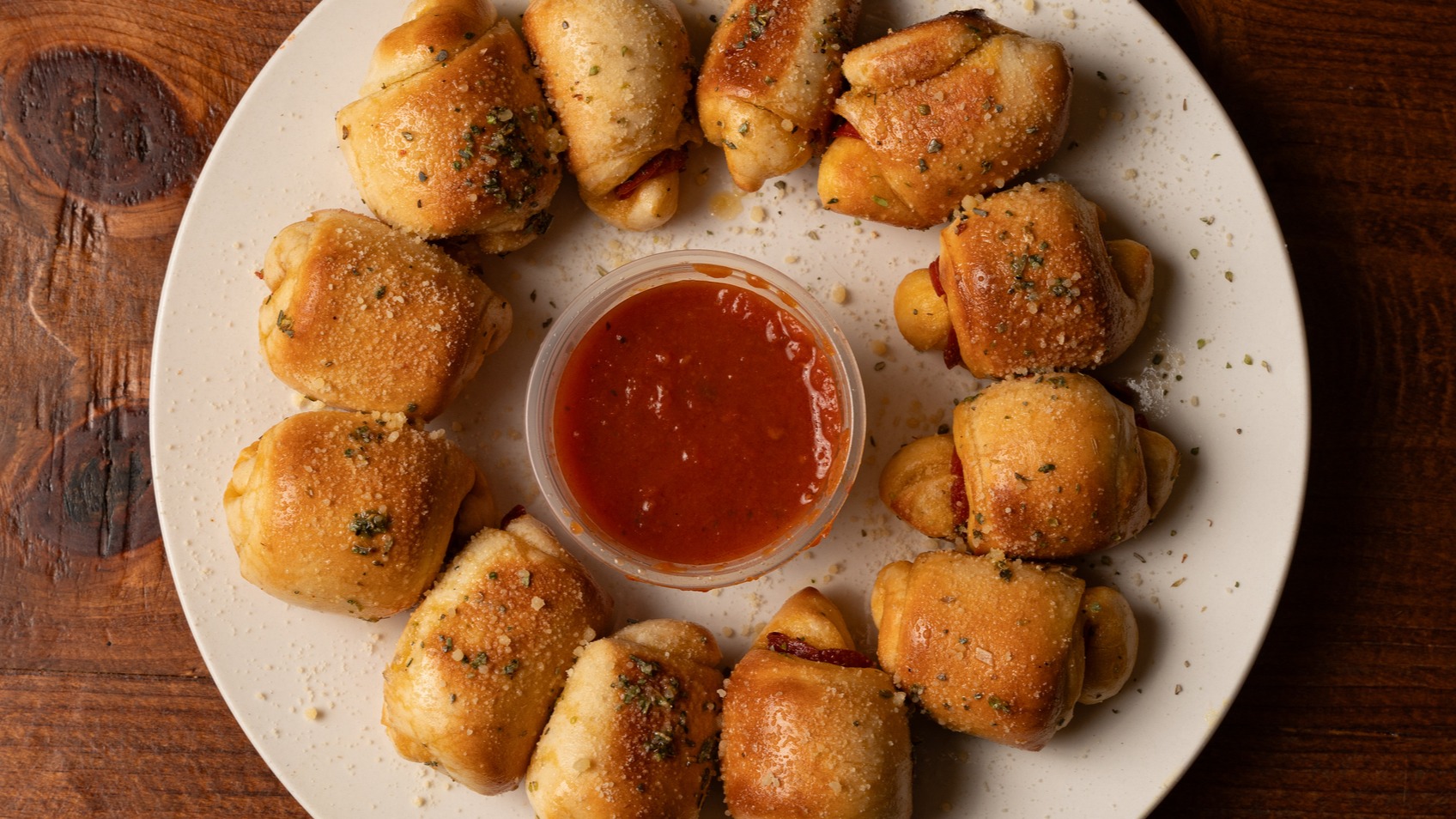 Ring of pizza croissants with cheese and pepperoni on plate with marinara dipping sauce