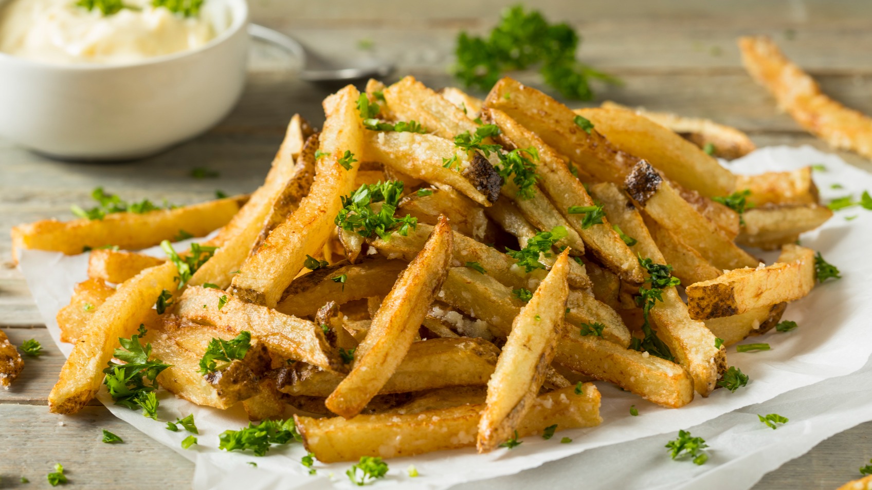 Ree Drummond's garlic parmesan fries on plate with parsley and garlic aioli like at the Mercantile restaurant