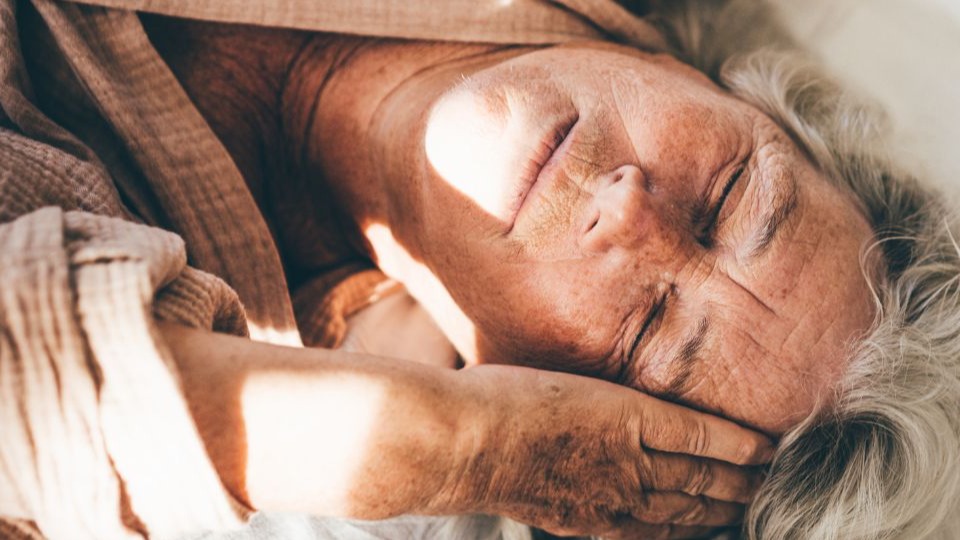 woman lying in bed holding her head unable to sleep