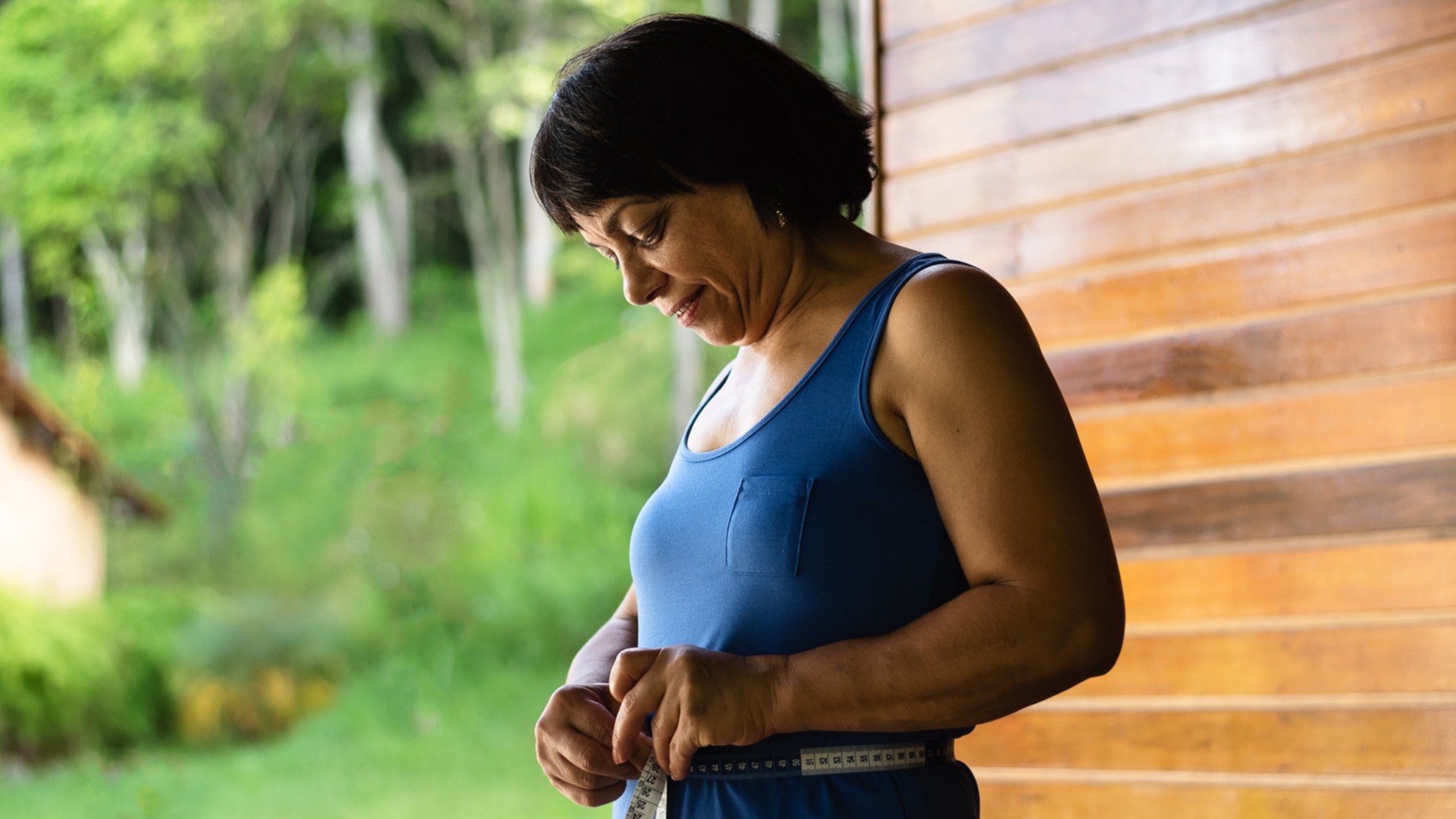 mature woman measuring her waist-to-hip ratio for heart health