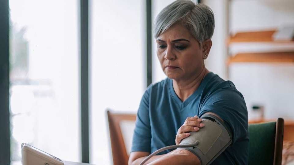 woman taking her own blood pressure at home