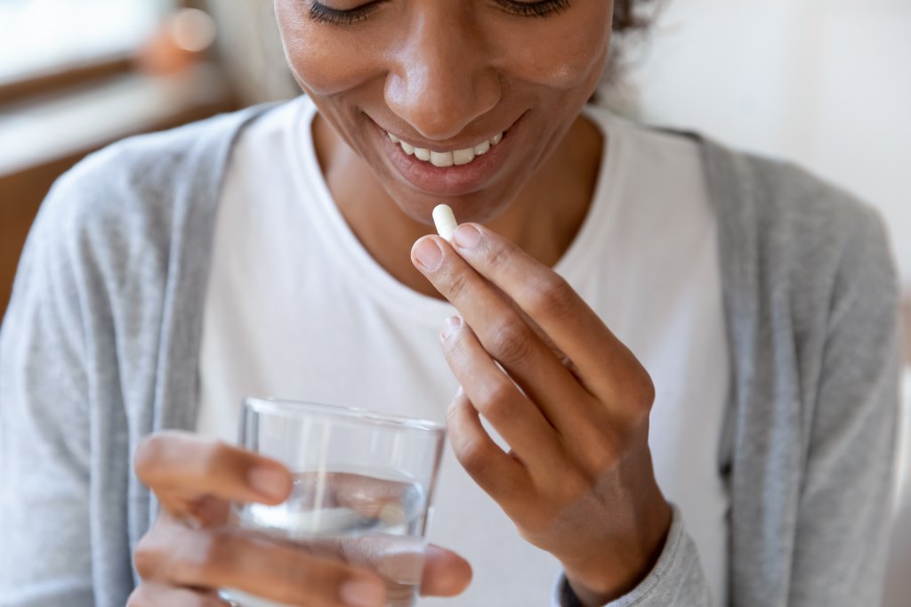 woman taking iron supplement for hair loss
