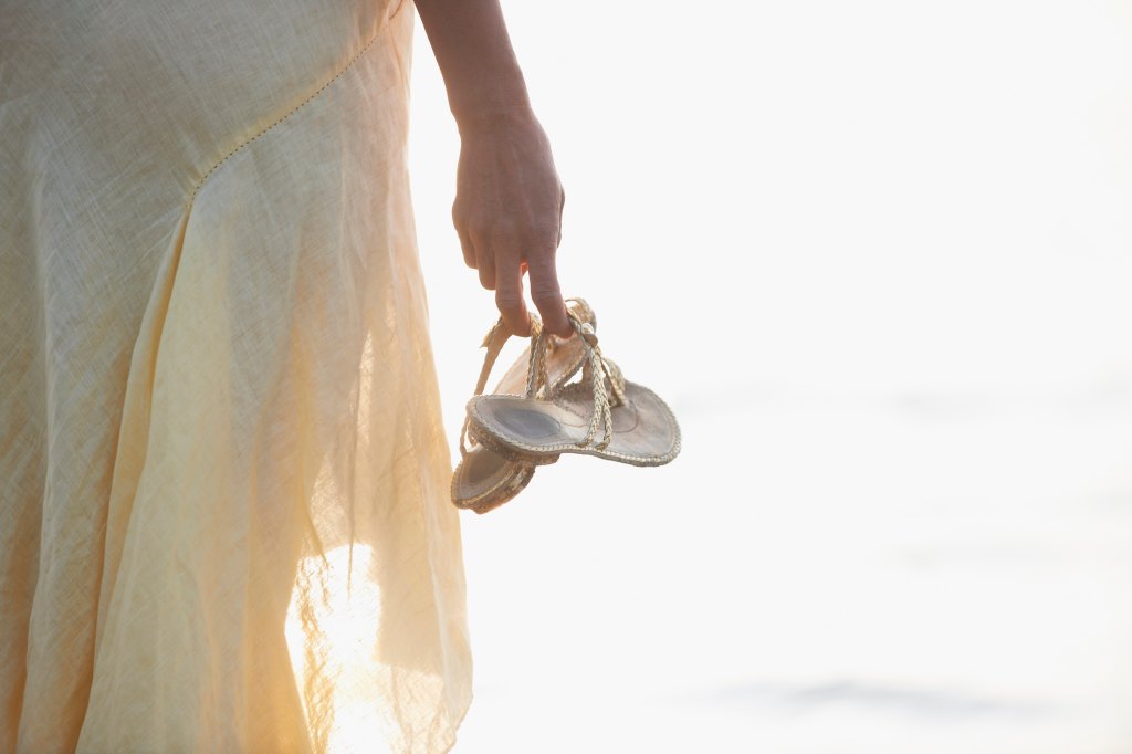woman carrying sandals