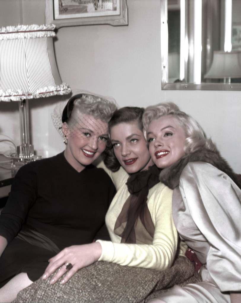 Betty Grable, Lauren Bacall and Marilyn Monroe pose for a portrait on the set of the 20th Century-Fox film 'How to Marry a Millionaire' in 1953 in Los Angeles, California