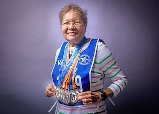 Marina Perez smiling with medals around her neck from the Golden Age Games