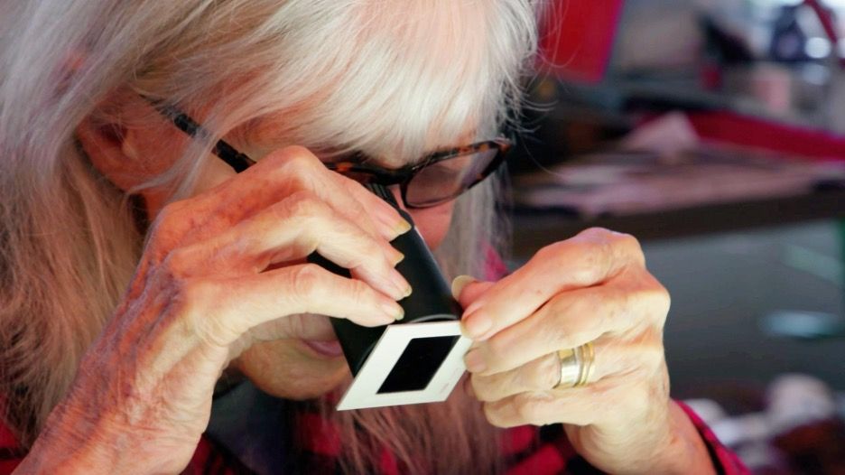 Jule Campbell examines an old Sports Illustrated Swimsuit Issue slide in Beyond the Gaze