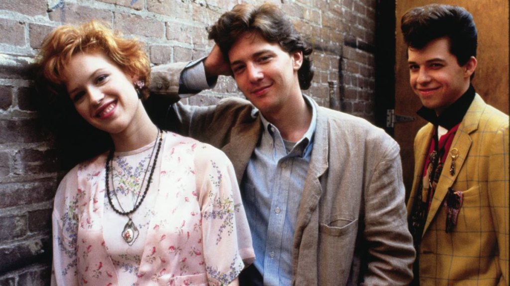 three people leaning against a wall