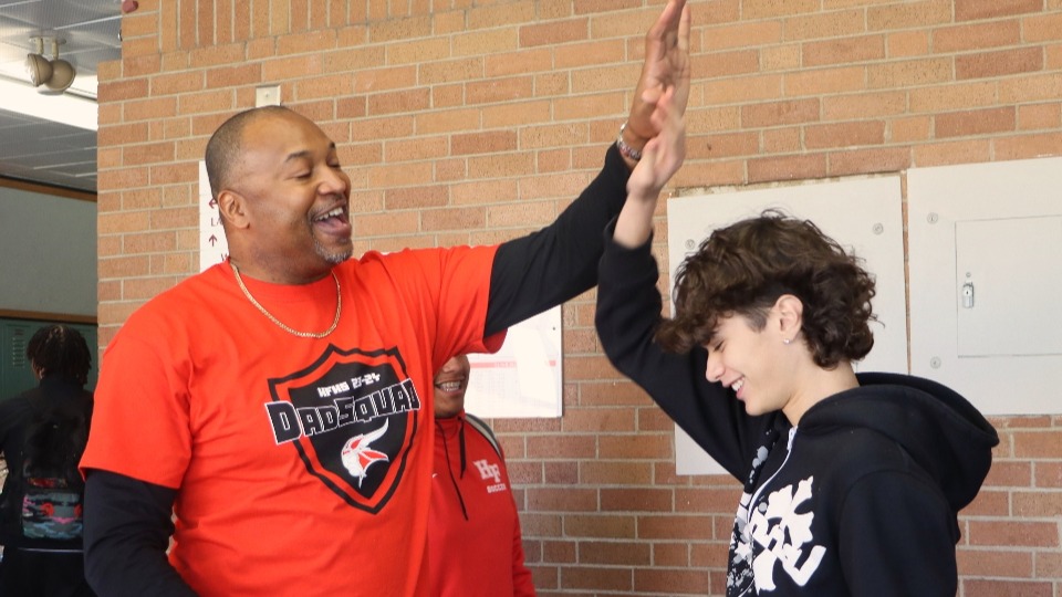 Percy Scott high fives a student