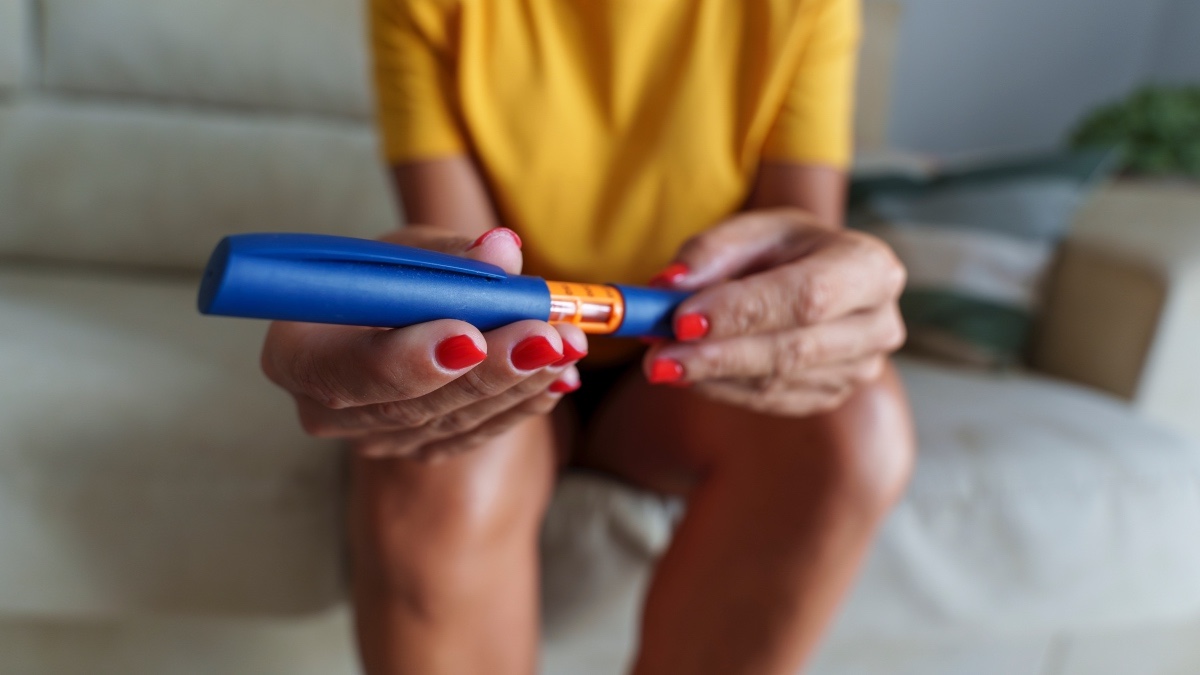 Close-up of a woman holding an Ozempic pen, which has a rare side effect of blindness