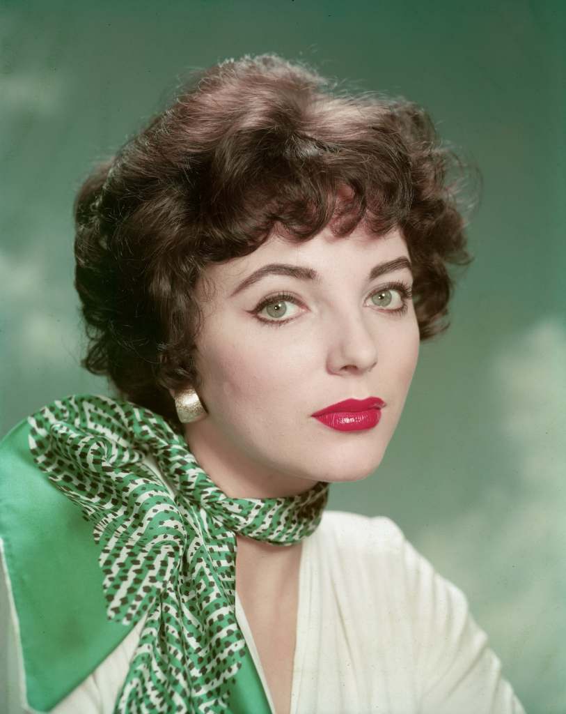 Joan Collins with green backdrop and scarf in 1955