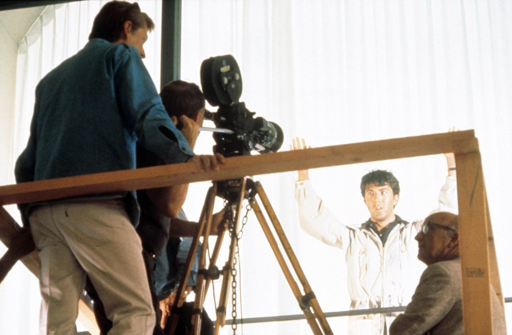 THE GRADUATE, director Mike Nichols (far left), Dustin Hoffman (beige windbreaker), on set, 1967