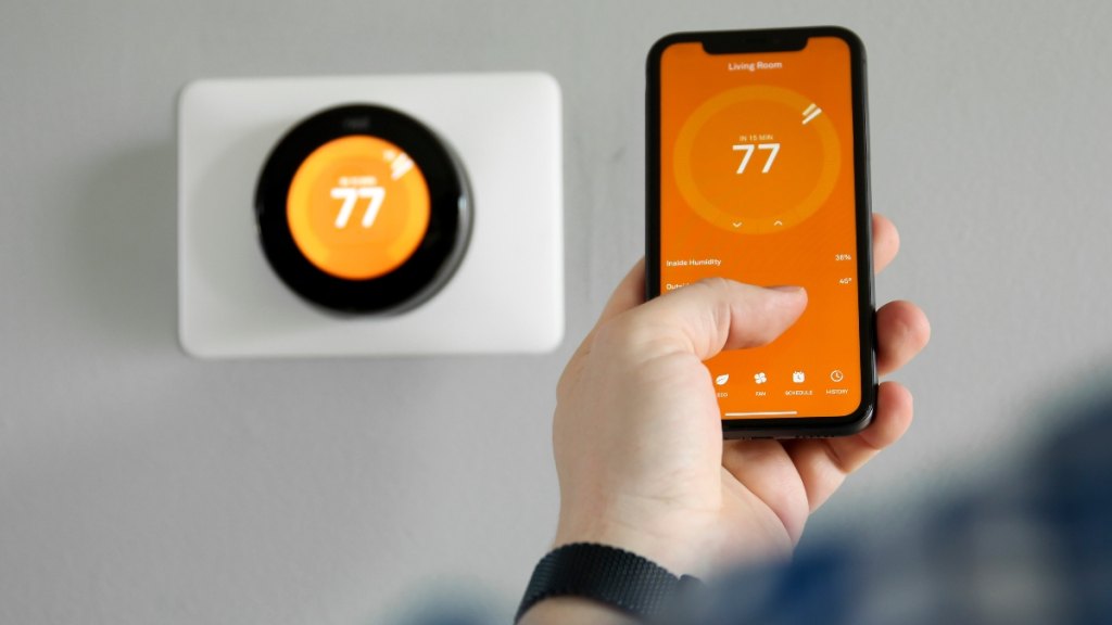 Man uses an app for his smart thermostat
