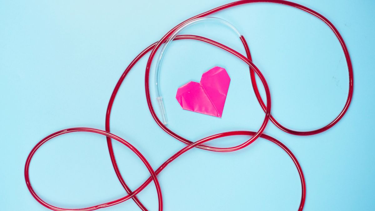 Red tube around a pink heart against a blue background