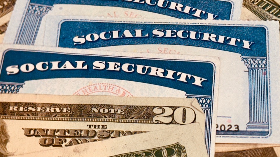Social Security cards surrounded by money
