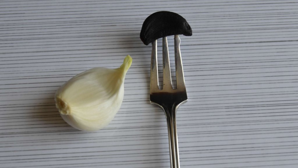 A clove of black garlic on a fork