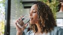 A woman drinking a glass of water to get instant relief from burning mouth syndrome