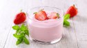A cup of protein Jell-O with strawberries and mint on a table