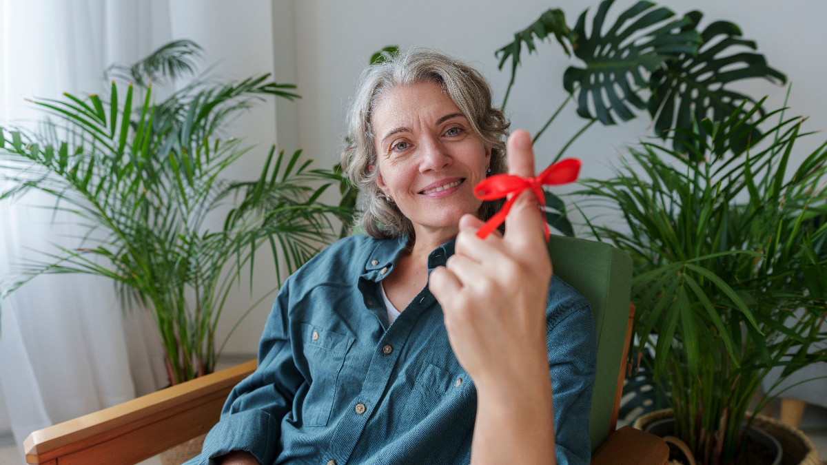 mature woman poses with red string to to her finger to help her remember something