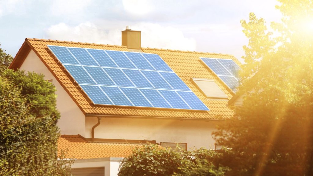 Solar panels on the tiled roof of the building in the sun. Electricity production for own needs and for sale