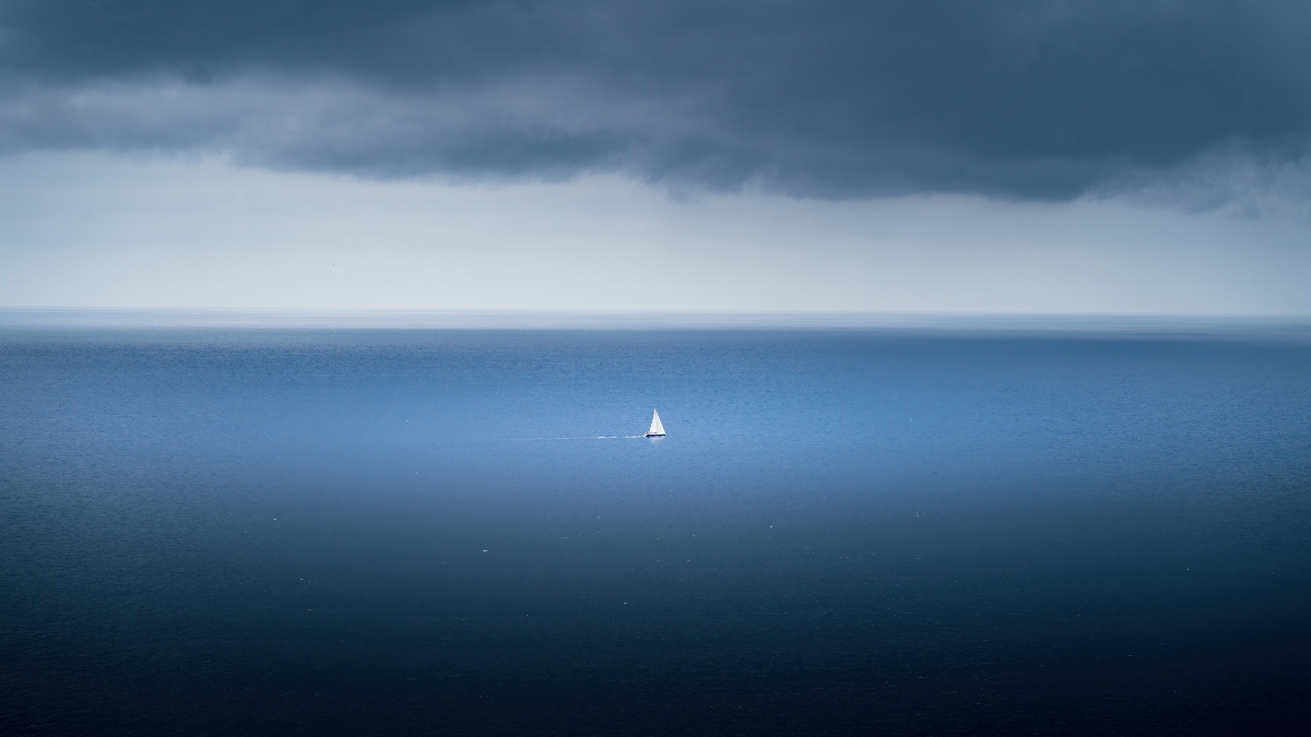 vast open ocean with boat sailing