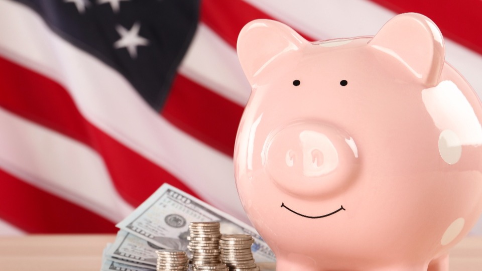 A piggy bank in front of an American flag