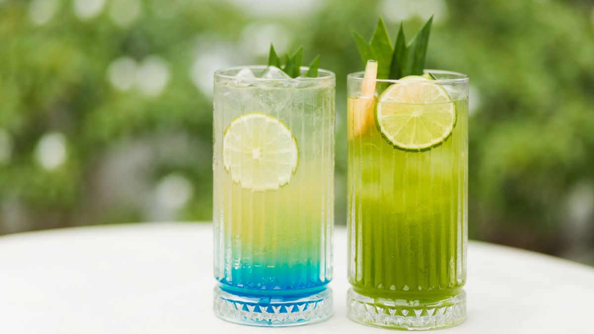 Two iced honeydew agua fresca drinks on top of a table