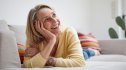 A woman with vaginal dryness smiling while lying on the couch
