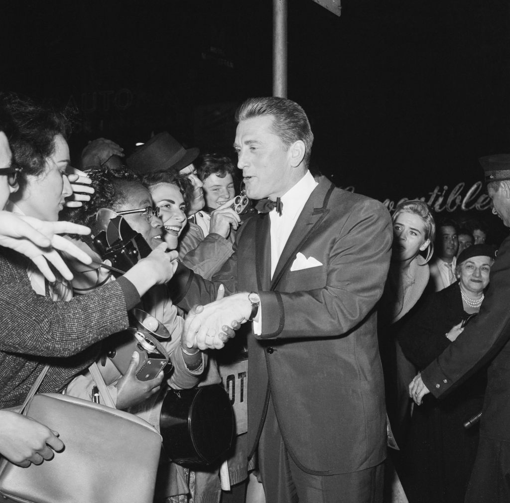 (Original Caption) Actor Kirk Douglas is besieged by camera toting outside the De Mille Theater here Oct. 6th, where he attended world premiere of his latest film, "Spartacus." The opening benefited the American Academy of Dramatic Arts.