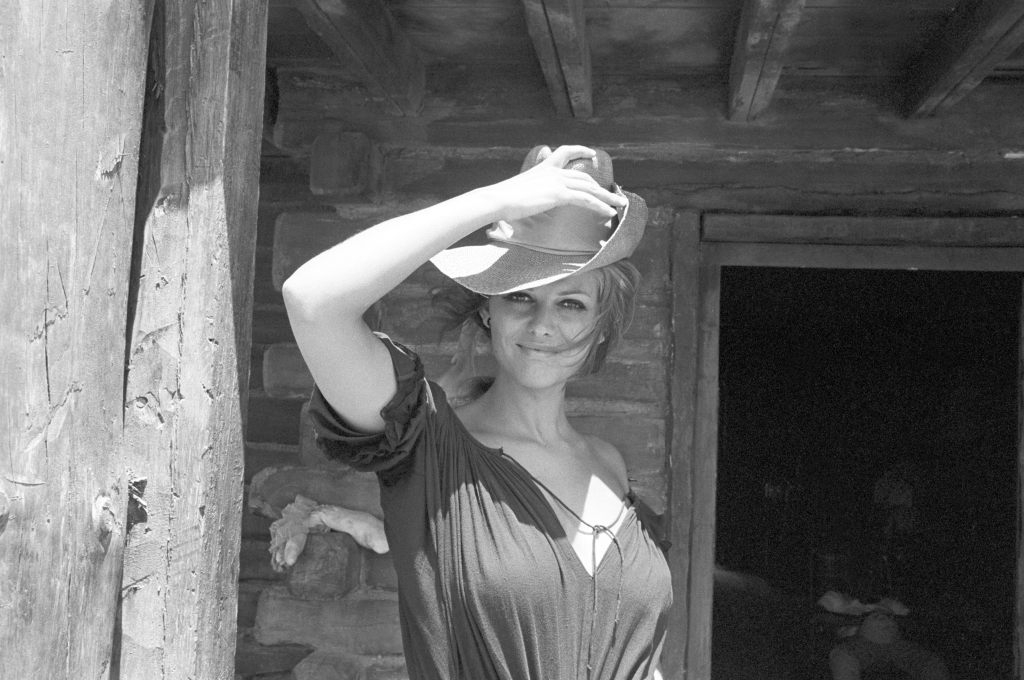 Italian actress Claudia Cardinale posing with a hat on the set of the film Once Upon a Time in the West