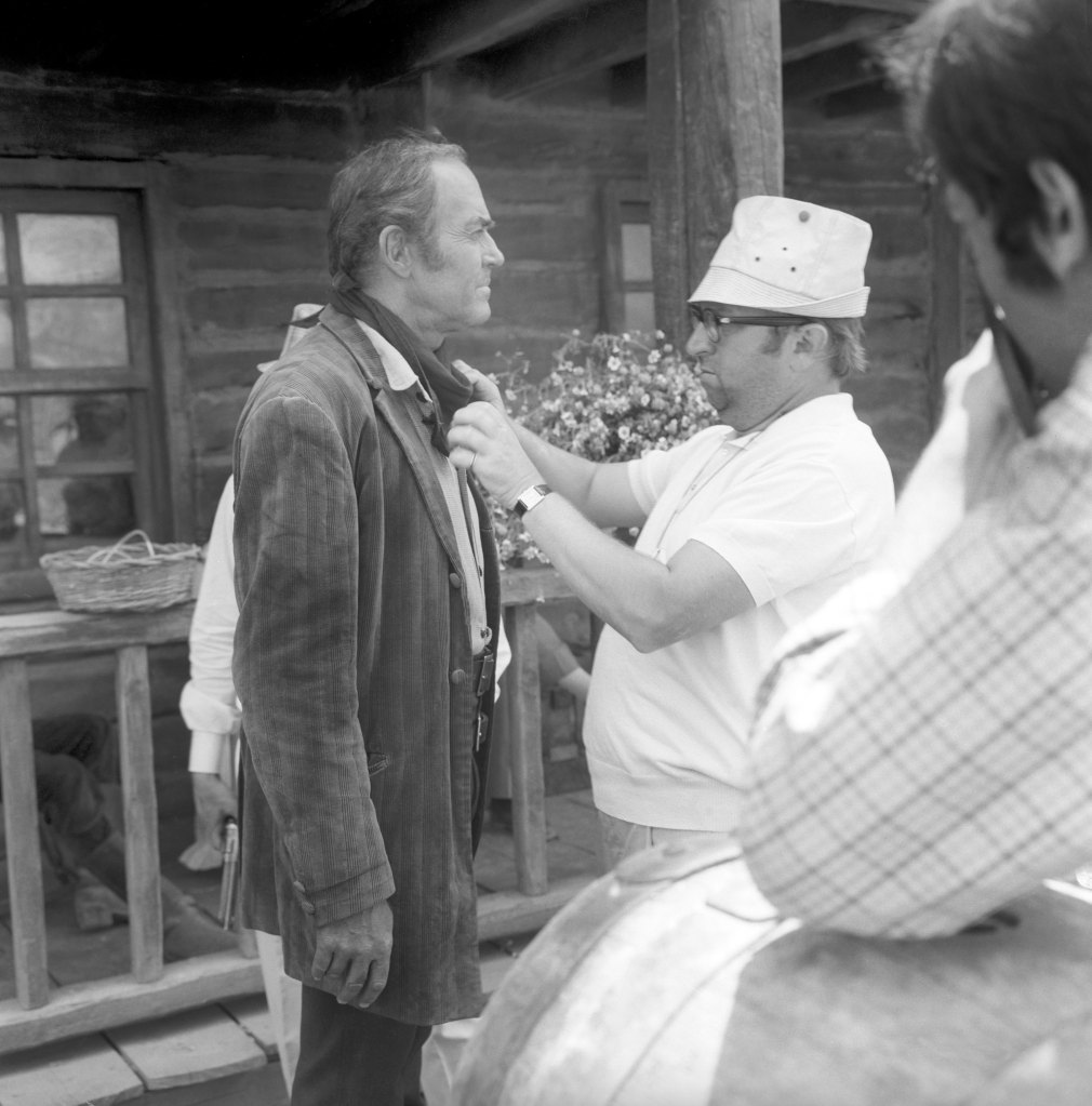Italian director Sergio Leone tidying the American actor Henry Fonda's scarf on the set of the film Once Upon a Time in the West