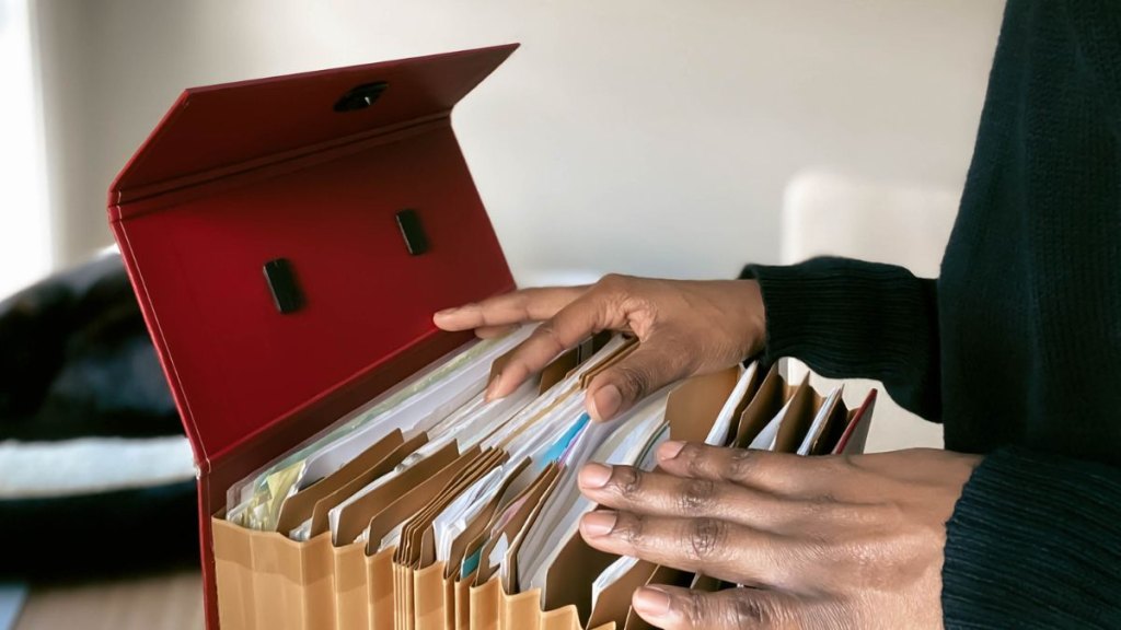 Close-up of unrecognizable black woman going through her files in home office
