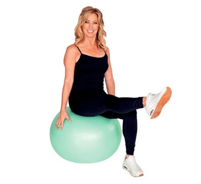 Denise Austin sits on a stability ball and demonstrates a seated leg lift.