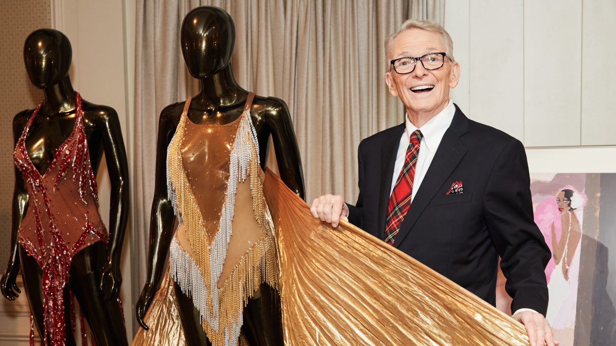 Bob Mackie poses with a costume he designed for Tina Turner