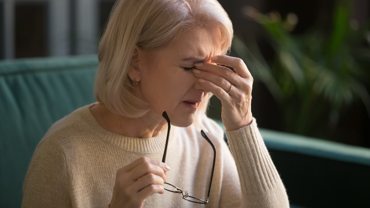 A woman rubbing her eyes due to blurry vision, a common symptom of glaucoma