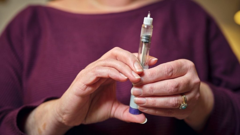 A woman prepares for a subcutaneous self-injection with a semaglutide pen 'diet drug' . The modern wonder weight loss drug and diabetes treatment highlights a personal healthcare routine at home